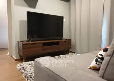 Modern living room with sleek TV setup and cozy gray sofa