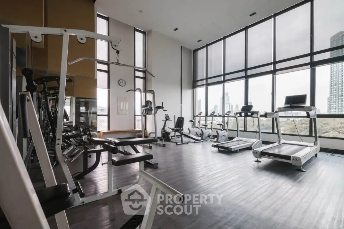 Spacious modern gym with city view and state-of-the-art equipment.