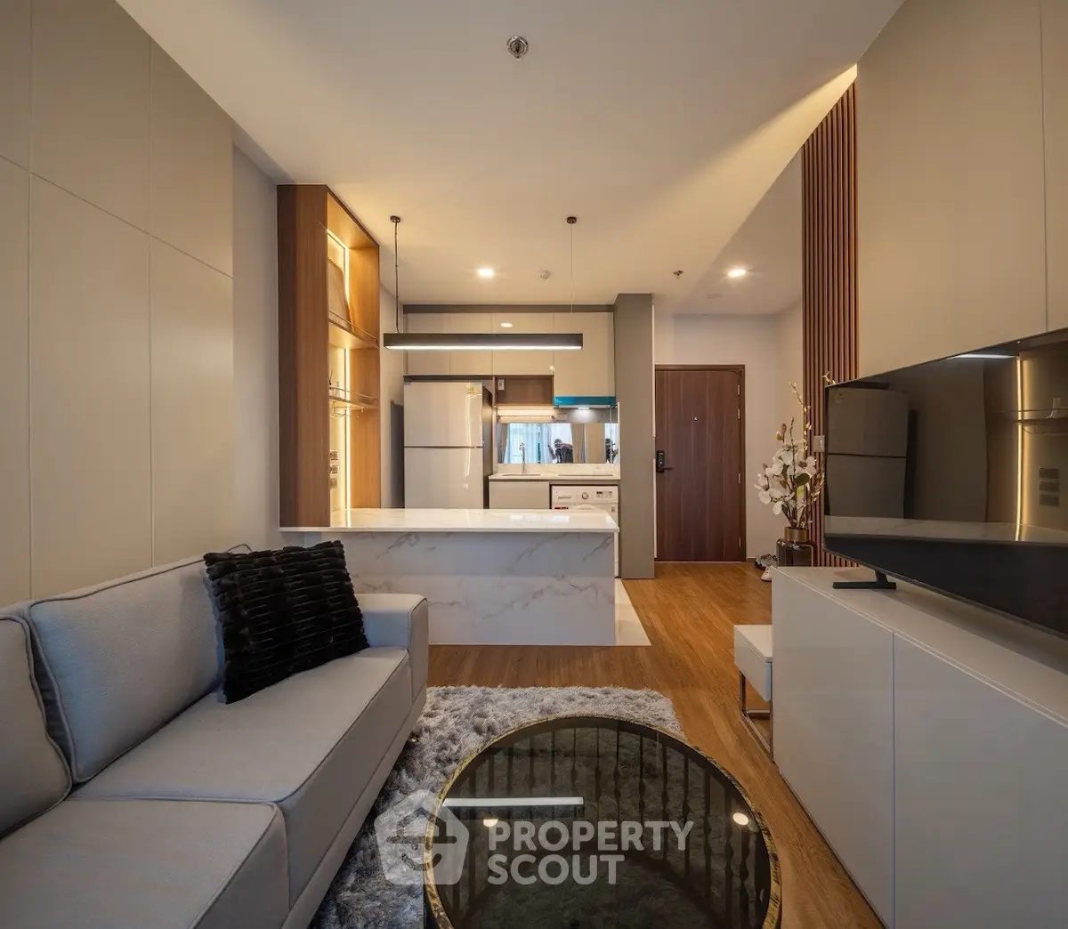 Modern living room with open kitchen, sleek design, and cozy ambiance