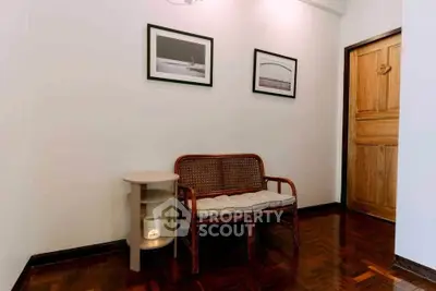 Cozy interior corner with wooden bench and framed art, perfect for relaxation.
