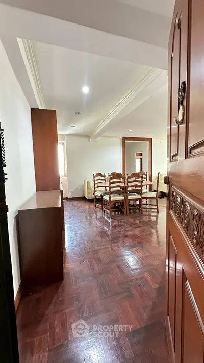 Spacious living room with wooden flooring and elegant dining set