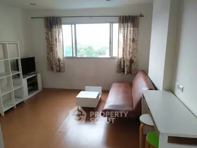 Cozy living room with large window and modern furniture, perfect for relaxation and entertainment.