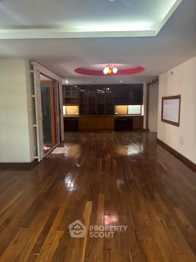 Spacious living room with wooden flooring and built-in shelving, ideal for modern living.