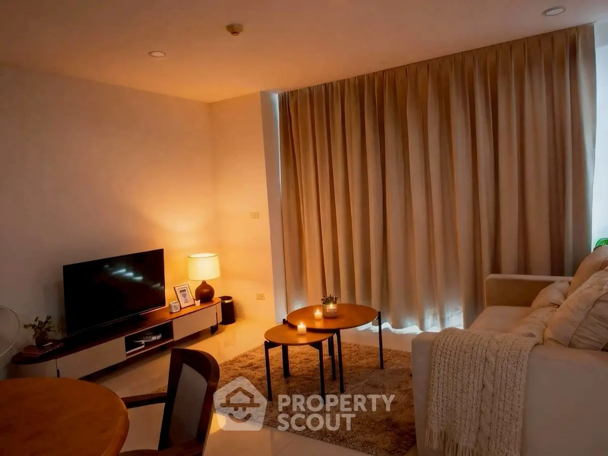 Cozy living room with warm lighting, modern furniture, and elegant curtains.