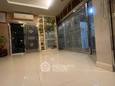 Spacious modern living area with elegant metal sliding doors and polished tile flooring.