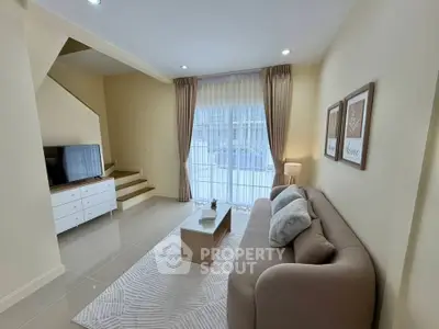 Spacious living room with modern decor and natural light, featuring a cozy sofa and stylish coffee table.