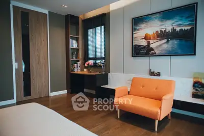 Stylish modern living room with orange sofa and cityscape artwork, featuring wooden flooring and built-in shelves.