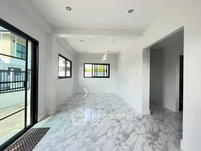 Spacious modern living room with marble flooring and large windows for natural light.