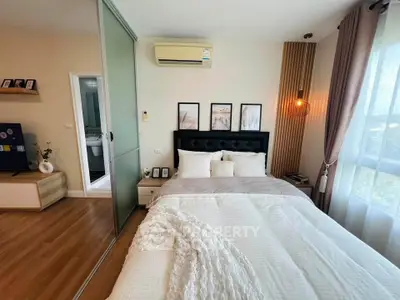 Cozy bedroom with modern decor, large window, and stylish lighting in a contemporary apartment.