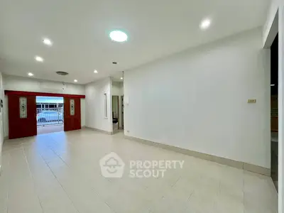Spacious empty living room with tiled floor and bright lighting, ideal for customization.