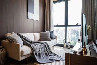 Stylish living room with city view, cozy sofa, and modern decor in high-rise apartment.
