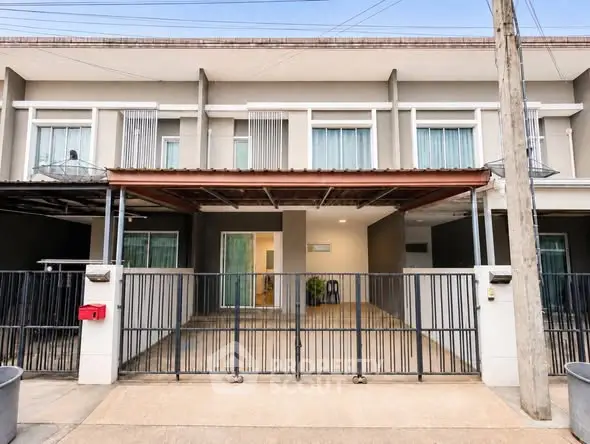 Modern townhouse exterior with gated entrance and spacious driveway.