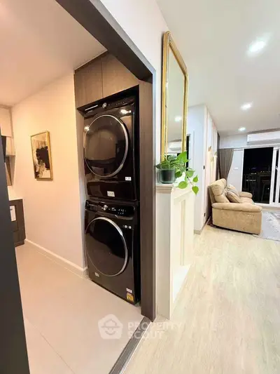 Modern apartment interior with stackable washer and dryer, cozy living room, and stylish decor.