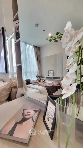 Modern bedroom with elegant decor and large window offering natural light.