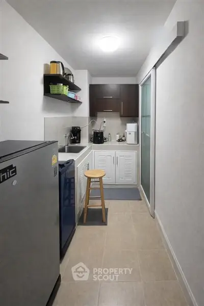Compact kitchen with modern appliances and sleek cabinetry in a cozy apartment.
