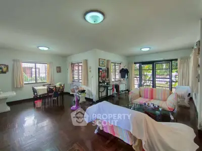 Spacious living room with hardwood floors and large windows in a cozy home.