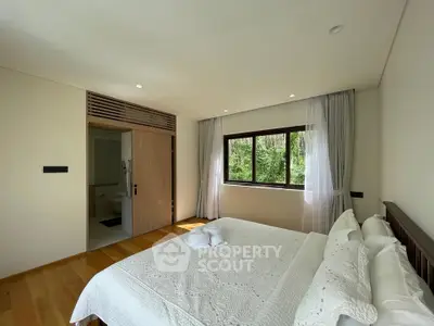Spacious bedroom with large window and elegant decor in modern home