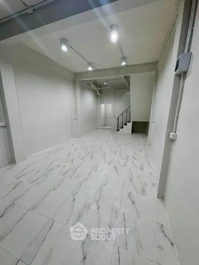 Spacious modern interior with sleek lighting and marble flooring, ideal for versatile use.