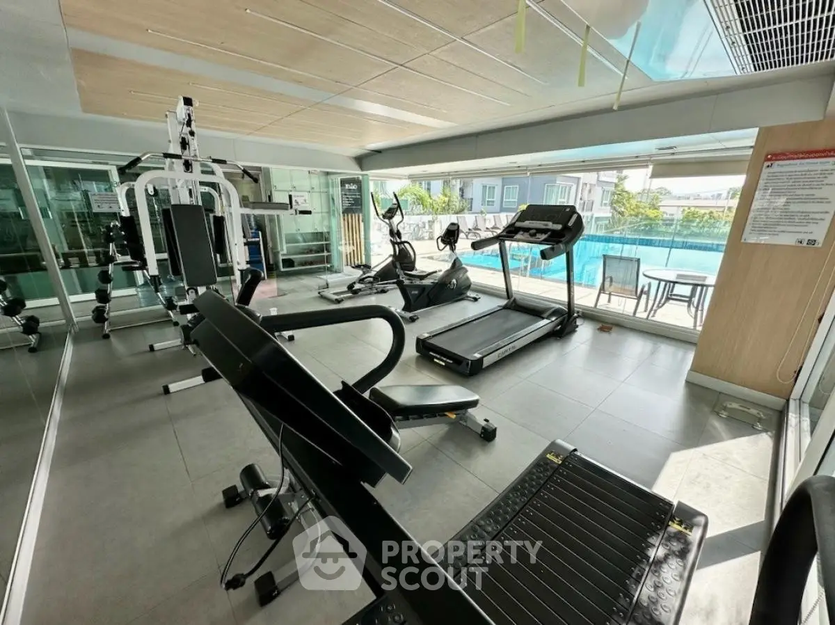 Modern gym with pool view in luxury residential complex