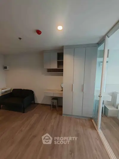 Modern living room with sleek furniture and wooden flooring in a contemporary apartment.