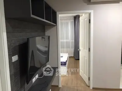 Modern apartment interior with TV and view into bedroom