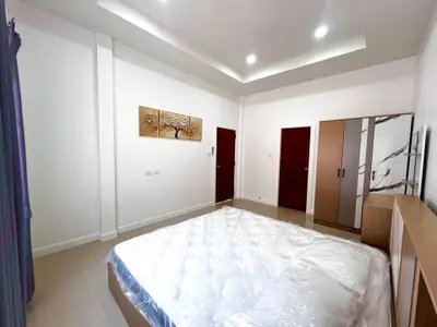 Spacious modern bedroom with elegant decor and ample natural light, featuring a cozy bed and stylish wardrobe.