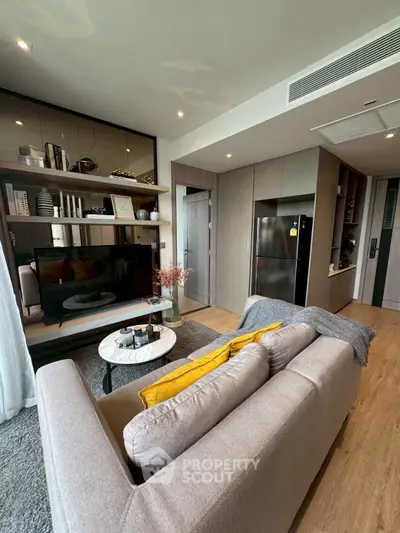 Modern living room with cozy sofa, stylish decor, and sleek kitchen appliances