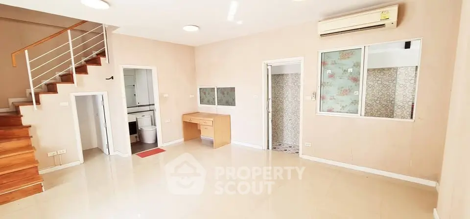 Spacious living room with staircase and air conditioning in modern home