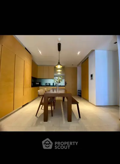 Modern kitchen with sleek wooden cabinetry and elegant dining area
