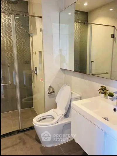 Modern bathroom with glass shower and sleek fixtures in a contemporary home.