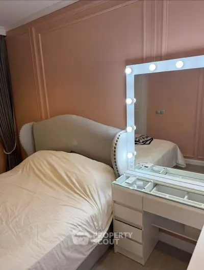 Chic bedroom with elegant upholstered bed and illuminated vanity mirror