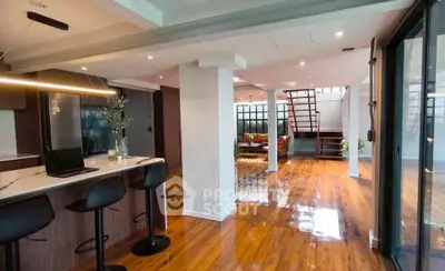 Stunning open-plan living area with modern kitchen and sleek wooden flooring