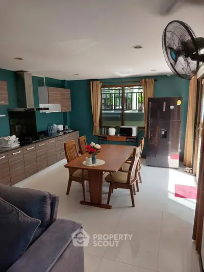 Spacious kitchen with dining area and modern appliances in a bright, airy setting.