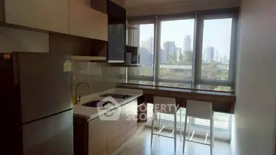 Modern kitchen with city view, featuring sleek appliances and breakfast bar seating.
