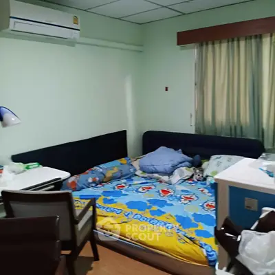Cozy bedroom with air conditioning and colorful bedding, perfect for a comfortable stay.