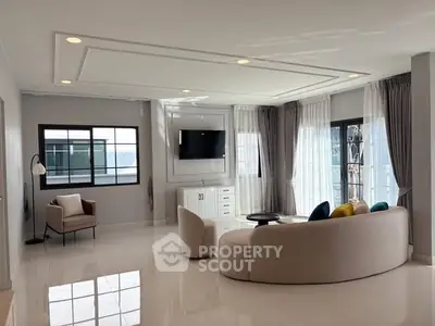 Spacious modern living room with elegant furniture and large windows.