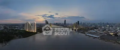 Stunning aerial view of city skyline with river and modern high-rise buildings at sunset.