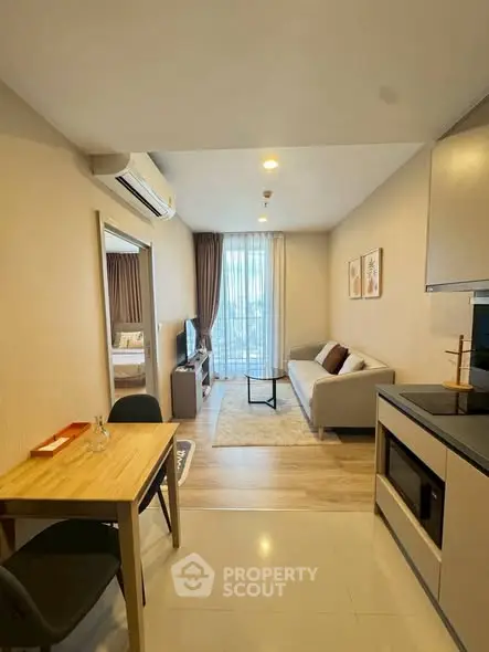 Modern living room with open kitchen and cozy decor in a stylish apartment.