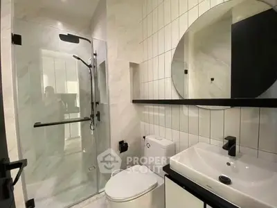 Modern bathroom with glass shower, sleek fixtures, and elegant tile design.