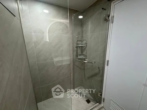 Modern bathroom with glass shower enclosure and sleek tile design.