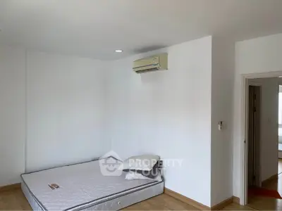 Spacious bedroom with minimalist decor and air conditioning in modern apartment.