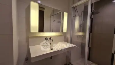 Modern bathroom with sleek sink and illuminated mirror