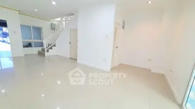 Spacious modern living room with sleek staircase and bright natural lighting