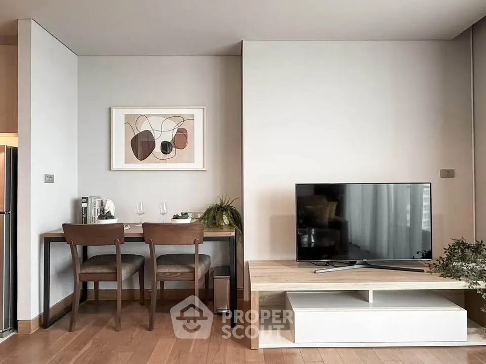 Modern living room with stylish decor, featuring a TV, dining area, and contemporary artwork.