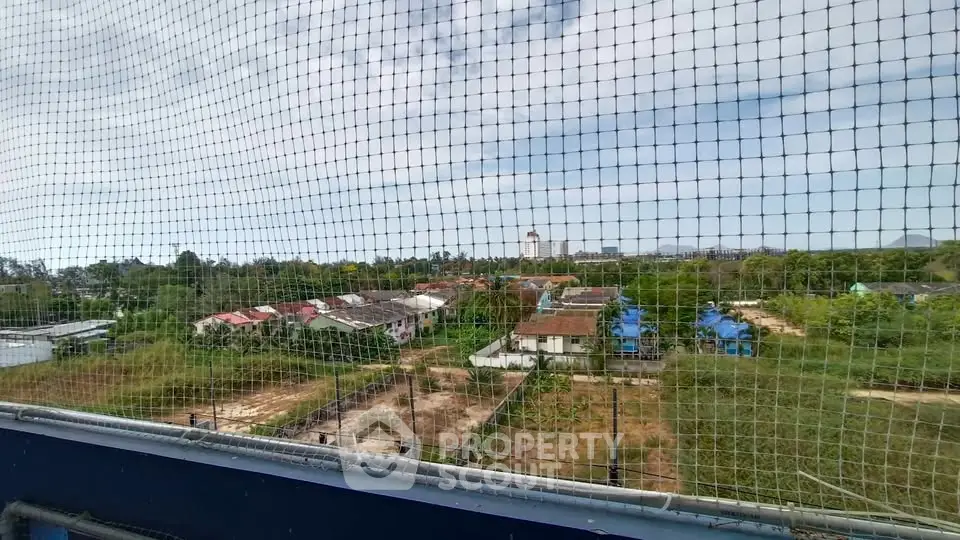 Scenic view of suburban houses and greenery from a high vantage point, showcasing potential real estate development.