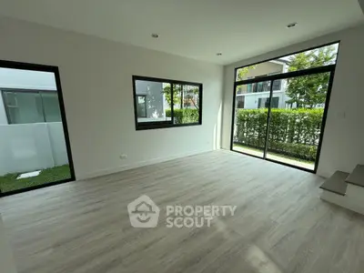 Spacious modern living room with large windows and garden view