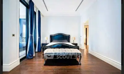Luxurious bedroom with elegant dark wood flooring and stylish black bed frame.