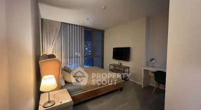 Cozy bedroom with modern decor and city view, featuring a comfortable bed and sleek furnishings.