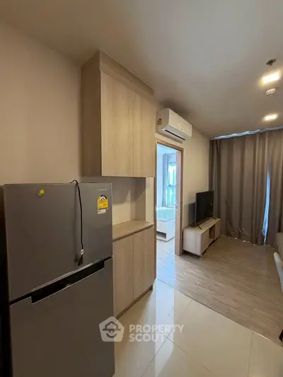 Modern apartment interior with open layout, featuring a sleek kitchen and cozy living area.