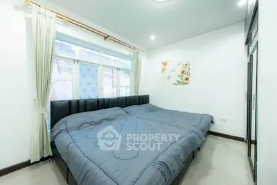 Spacious bedroom with large bed and natural light from window